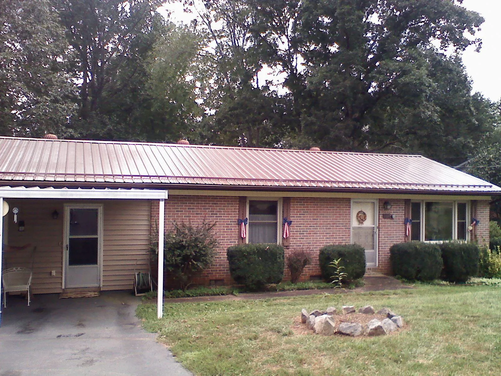 Bronze metal roof and carport on a brick ranch home — Roof Repair work by our crew in Goldsboro